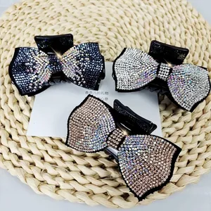 Detailed view of three bow hair claws with sparkling rhinestones in assorted colors