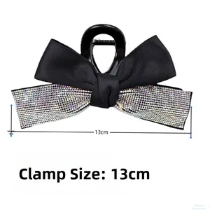 Détail d'une pince à cheveux nœud noir de 13cm avec strass pesant 44g sur fond blanc