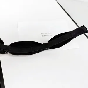 Detail of slim black fabric headband with dark bead trim and anti-slip teeth grip