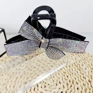 Elegant large hair claw clip with a shimmering rhinestone bow design for stylish women