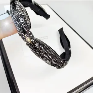 Macro detail of black knotted headband with sparkling silver rhinestones for women