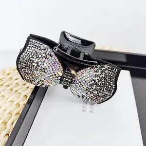 Close-up of black velvet bow hair claw clip with shimmering rhinestones and crystals