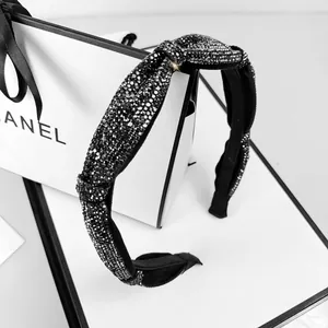 Close-up of sparkling black rhinestone headband with elegant twist knot detailing