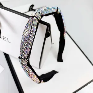 Close-up of a sparkling rhinestone headband with colorful crystals and a twist design