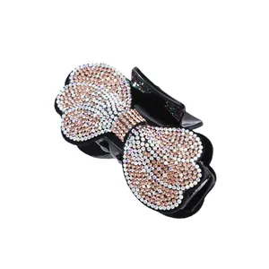 Elegant bow-shaped hair claw clip with pink rhinestones on a clean white background