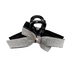 Close-up of elegant black rhinestone bow hair claw clip with sparkling silver crystals