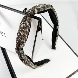 Macro detail of sparkly rhinestone headband with elegant knotted design and silver crystals