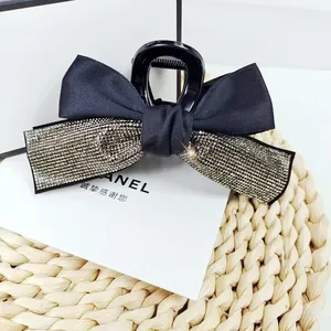 Détail d'une pince à cheveux à nœud noir élégant avec garniture de strass argentés