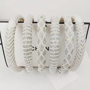 Elegant set of six pearl and rhinestone headbands with a minimalist white gift bag background