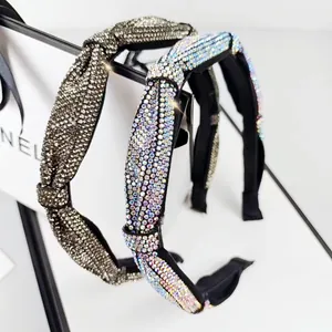 Macro detail of sparkling rhinestone headband set with twisted knot design in dark grey and AB