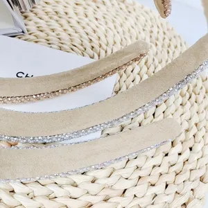 Detailed view of beige suede headbands with pearls, sequins and sparkling rhinestones