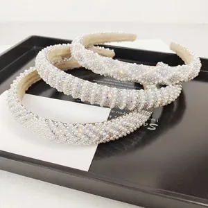 Detailed macro view of three thick padded headbands with pearls and colorful rhinestones