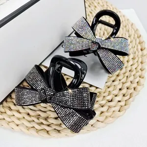 Gros plan de pinces à cheveux en forme de nœud ornées de strass brillants multicolores
