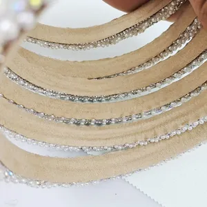 Detail of elegant headband featuring white pearls and colorful rhinestones on fabric