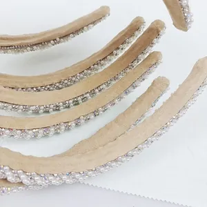 Close-up of pearl and rhinestone embellishments on velvet padded headbands stacked together