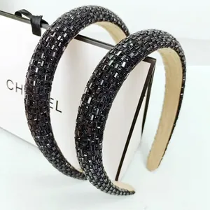 Close-up of black rhinestone padded headband with sparkling crystal embellishments