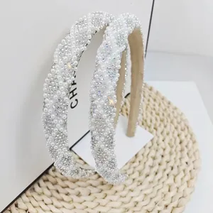 Detail view of woven white faux pearls and shimmering rhinestones on a narrow headband