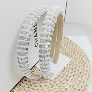 Detailed view of handmade wide headband with white faux pearls and colorful rhinestones