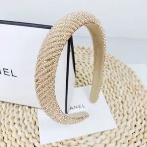Detail of champagne gold padded headband with rows of small pearls and rhinestones