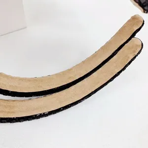 Detailed view of black rhinestones and soft beige velvet lining on the fashion headband