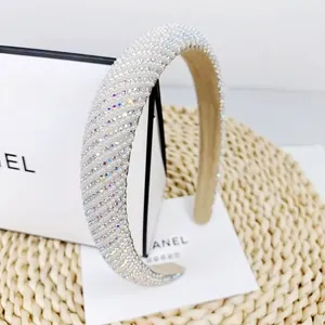 Detailed close-up of a padded pearl headband with sparkling rhinestones on woven texture