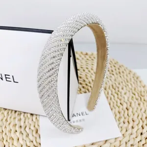 Detail of elegant headband with pearls and rhinestones on a woven texture background