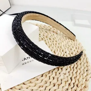 Elegant black rhinestone padded headband with crystal embellishments on white gift box