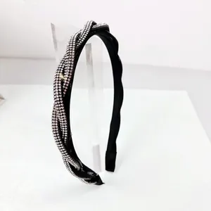 Close-up of twisted headband with dense rhinestones on a black base for women