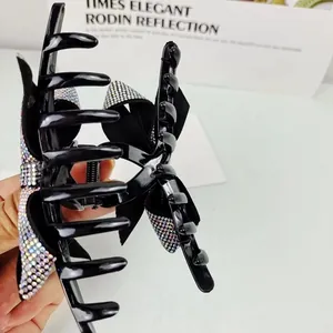 Molla per capelli nera lucida con fiocco di strass per un look elegante da donna