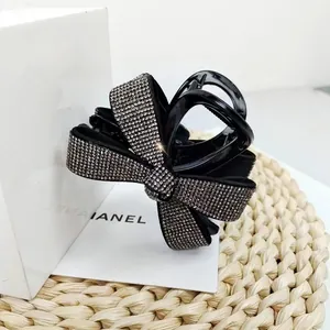 Gros plan d'une pince à cheveux nœud noir ornée de strass argentés brillants de luxe