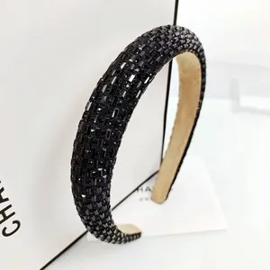 Close-up of thick black velvet headband with shimmering square-cut crystal embellishments
