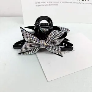Dettaglio ravvicinato di strass colorati su una pinza per capelli nera a fiocco elegante
