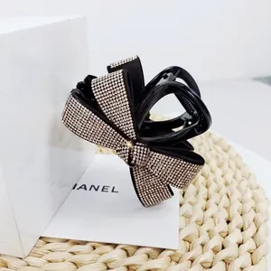 Détails d'une pince à cheveux nœud noir ornée de strass argentés brillants et luxueux