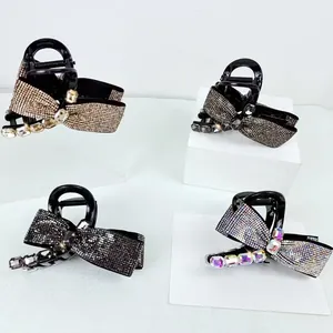 Detail view showing four colors of elegant bow hair claws with sparkling rhinestones