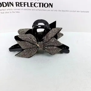 Dettaglio di una grande pinza per capelli nera con un fiocco di strass scintillanti