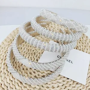 Detailed view of white padded headbands with pearls and sparkling rhinestones
