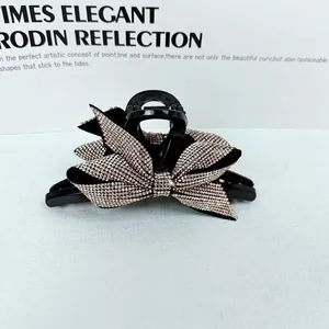 Dettaglio della molletta per capelli nera con un elegante fiocco decorato di strass