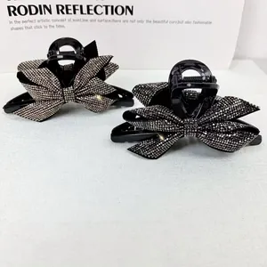Dettaglio di eleganti mollette a forma di fiocco con strass brillanti incastonati
