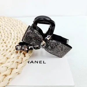Close-up of elegant black bow hair claw with sparkling crystals and dark gemstones
