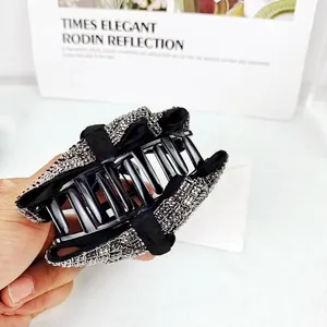 Vue détaillée de la pince à cheveux en tissu noir ornée de strass brillants et élégants