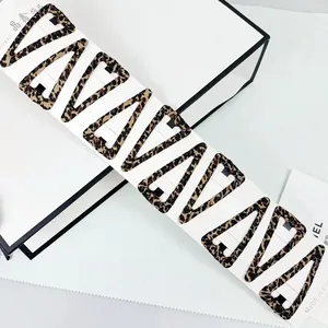 Detailed view of ten triangular leopard print BB hair clips on a white display card