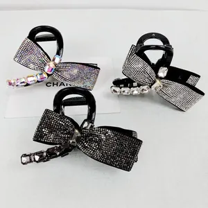 Detailed macro view of bow-shaped hair claws with multi-colored shimmering rhinestones