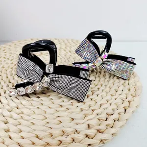 Detailed macro view of black resin bow hair claw clips with shimmering rhinestones
