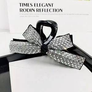 Macro view of crystal rhinestones on a black bow hair claw clip for elegant hair styling