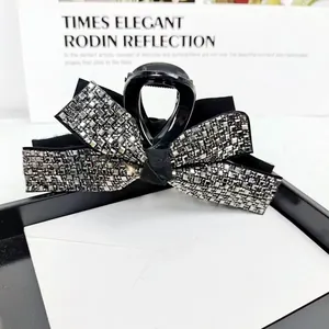 Elegant large shark hair claw with silver rhinestones on a black bow-shaped resin clip