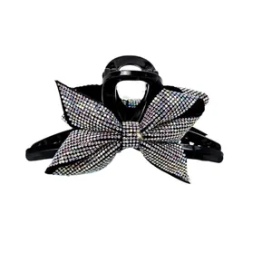 Elegante pinza per capelli con fiocco di strass colorati su una base nera
