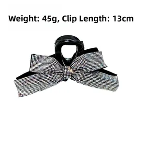 Détail d'une pince à cheveux nœud en cristal de 13cm pesant 45g avec strass noirs et base