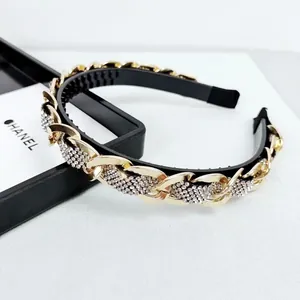 Elegant baroque headband featuring gold metal chains and sparkling white rhinestones