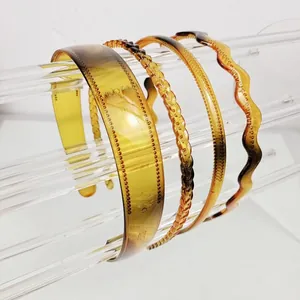 Detail view of four amber resin headbands including braided and wavy styles on a white base