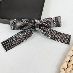 Macro detail of a crystal-encrusted bow hair clip with shimmering rhinestones